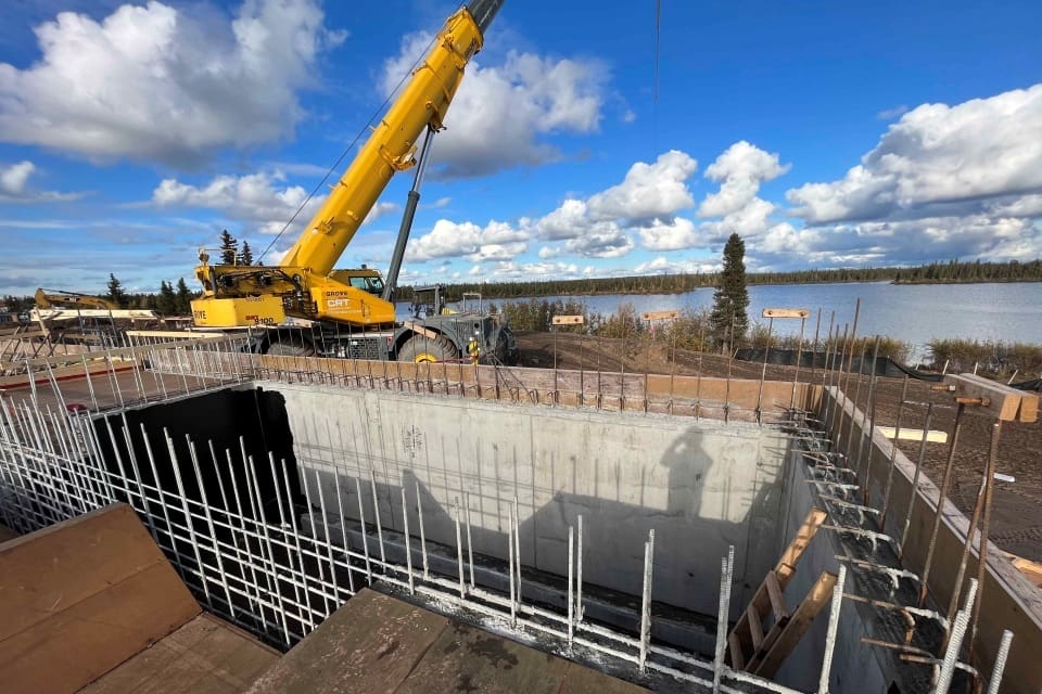 Fondations de béton en construction devant un plan d'eau
