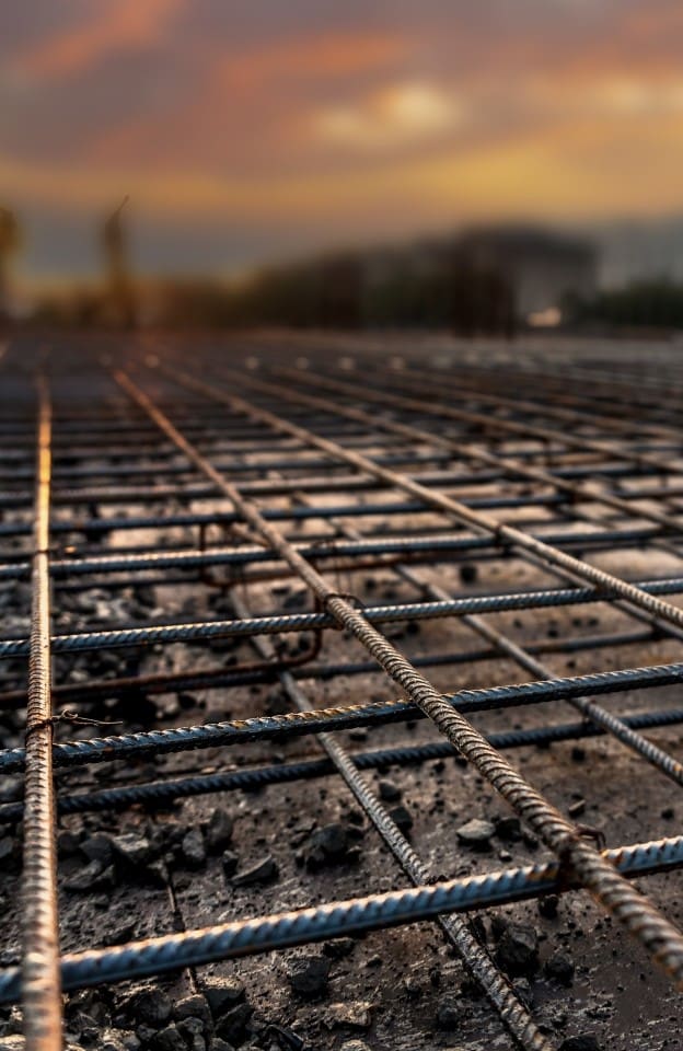 Chantier de construction au coucher du soleil – Armature de l’étage intermédiaire et colonnes d’un bâtiment en construction.