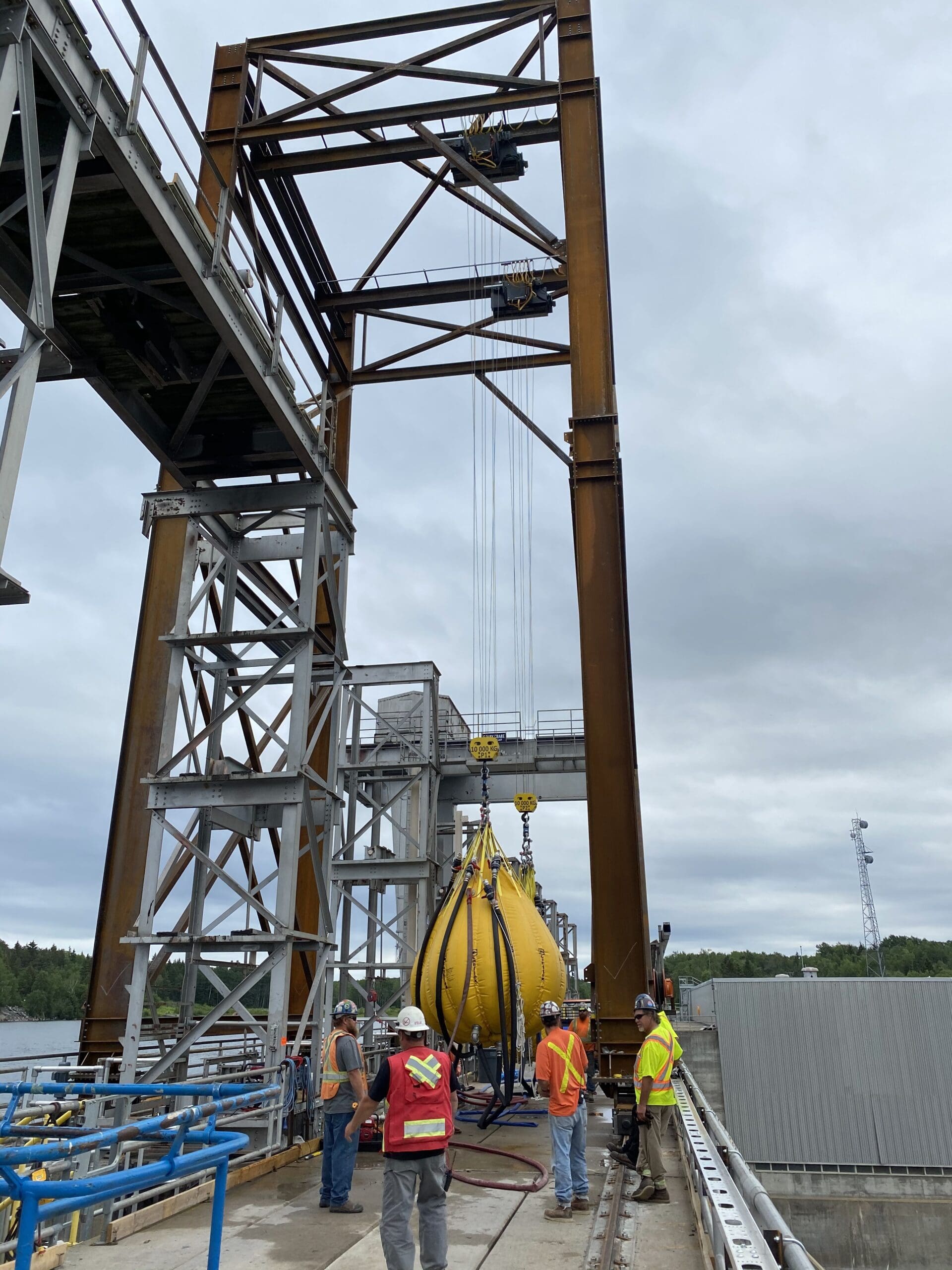 hommes travaillant sur un chantier de construction d'un barrage hydro-électrique avec une gantry 2x10T